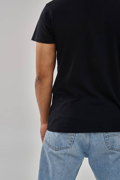 стильна афроамериканська чоловіча модель позує в чорній футболці і джинсах, копіює простір для реклами - Фото, зображення