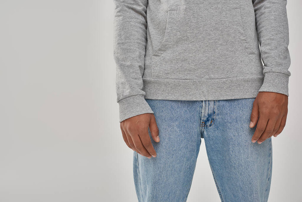 стильний афроамериканський чоловік у сірому повсякденному светрі та джинсах, копіює простір для реклами - Фото, зображення