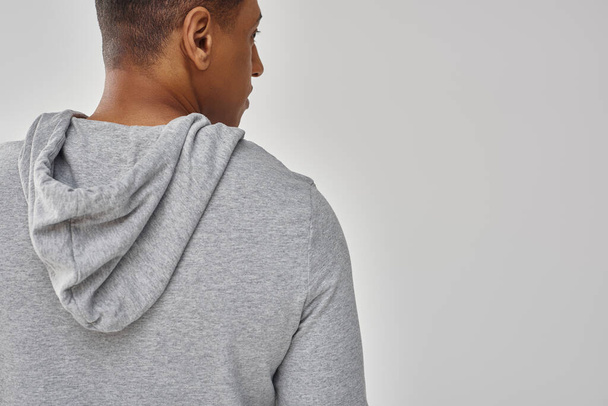 élégant homme afro-américain en sweat-shirt décontracté sur fond blanc, espace de copie pour la publicité - Photo, image