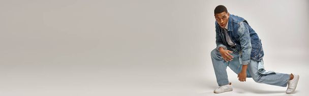 όμορφος συναισθηματικός Αφροαμερικάνος με denim στολή σε λευκό φόντο, fashion concept, banner - Φωτογραφία, εικόνα