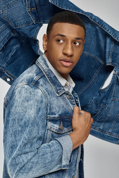 young trendy african american man in stylish denim outfit posing on white backdrop, fashion - Photo, Image