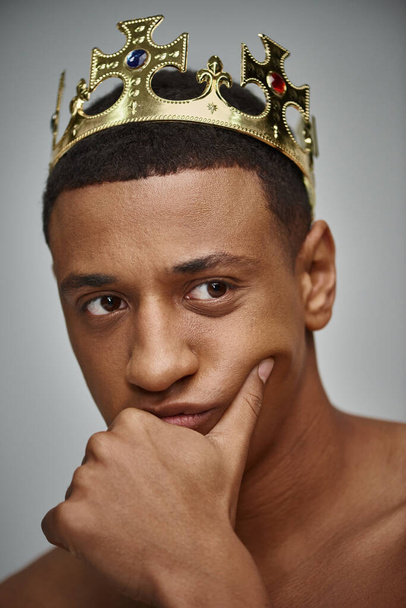 atractivo hombre afroamericano en la corona de oro posando en topless con la mano cerca de la cara, concepto de moda - Foto, Imagen