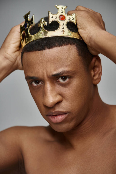 соблазнительный молодой афроамериканец, позирующий без топора с золотой короной, модная концепция - Фото, изображение