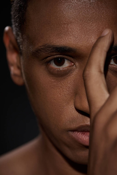 close up of handsome appealing african american man with hand in front of face, fashion concept - Photo, Image