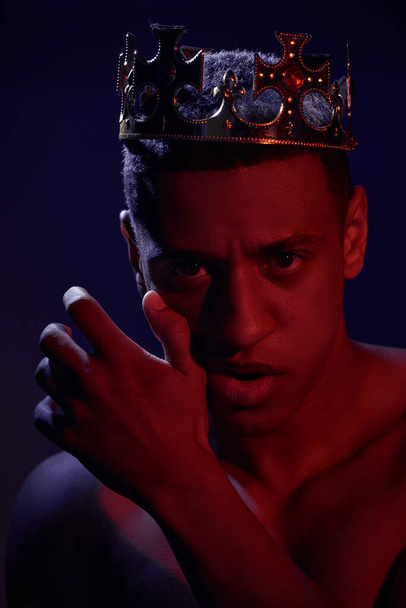 portrait of sexy shirtless african american man in golden crown posing in lights, fashion concept - Photo, Image