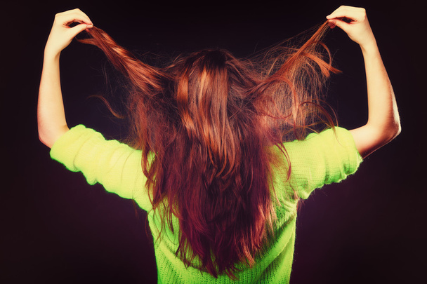 Young woman pulling her long hair. - Фото, изображение