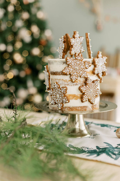 Hermoso pastel de cumpleaños en la cocina decorada de Navidad con árbol de Navidad. Foto de alta calidad - Foto, Imagen