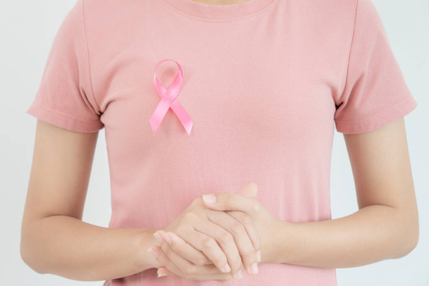 Женщина держит розовую ленточку осознания рака молочной железы. Женское здоровье проверяет сознание. Международный день женщин и Всемирный день борьбы с раком. подписать рак, Символика, здравоохранение, поддержка пациентов, своевременная диагностика - Фото, изображение