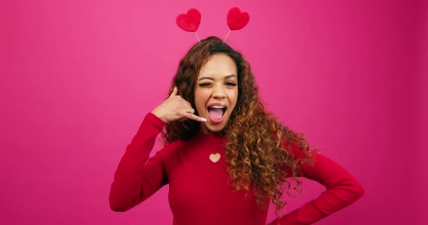 Флиртующая молодая женщина делает знак "Зови меня", тайный поклонник Дня Святого Валентина, студия. Высококачественные 4k кадры - Кадры, видео