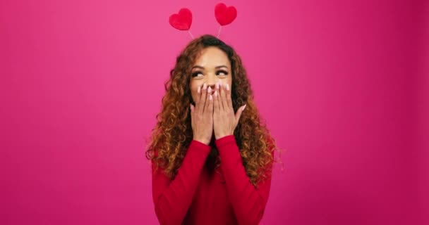 Скромная и кокетливая молодая женщина хихикает на тайного поклонника, День Святого Валентина студия розовый. Высококачественные 4k кадры - Кадры, видео