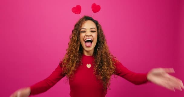 Mujer sonriente cubre los ojos como sorpresa para el Día de San Valentín, estudio rosa. Imágenes de alta calidad 4k - Imágenes, Vídeo