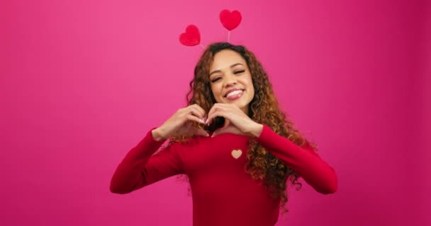 Šťastná roztomilá mladá žena dělá gesto ruky srdce, Valentines Day studio. Vysoce kvalitní 4K záběry - Záběry, video