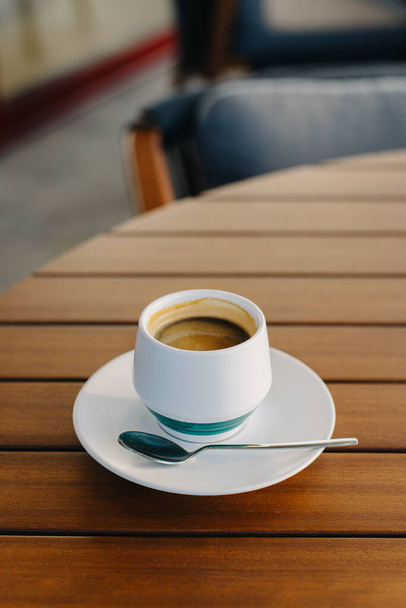 Una taza de café negro en una mesa en un café. Lugar para el texto. - Foto, Imagen