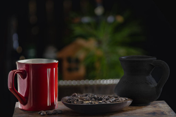 Czerwona filiżanka i ziarna kawy z selektywnym ukierunkowaniem - Zdjęcie, obraz