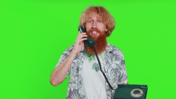 Hey you, call me back. Young man talking on wired landline vintage telephone of 80s, advertising proposition of conversation, online shopping. Redhead bearded guy isolated on chroma key background - Footage, Video
