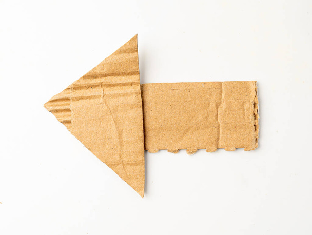 Картонна стрілка ізольована, стрілки з картону шматок, розрізаний крафт-папір, коричнева обгортка Вінтажний папір стрілка ізольовані зверху - Фото, зображення