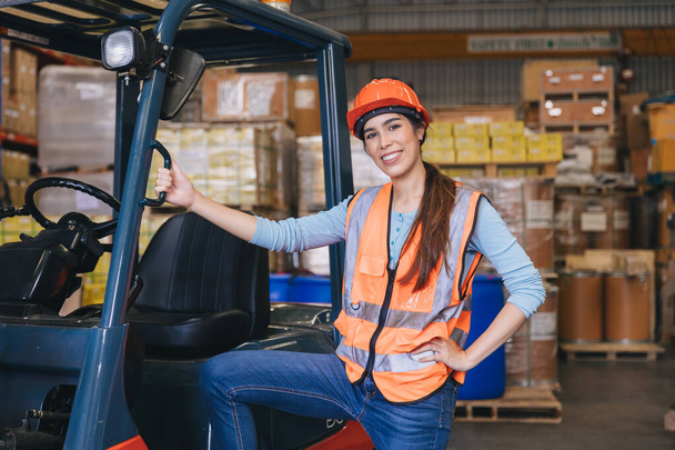 счастливая женщина работница вилочного погрузчика работает в складской логистики погрузки грузов отрасли хранения продукции - Фото, изображение