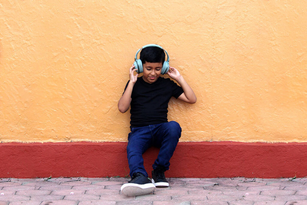 Καφέ Λατίνο 9χρονο αγόρι με ακουστικά κατά του θορύβου για παιδιά με σύνδρομο Asperger, διαταραχή φάσματος αυτισμού, ΔΕΠΥ και παιδιά με ευαισθησία σε δυνατούς θορύβους - Φωτογραφία, εικόνα
