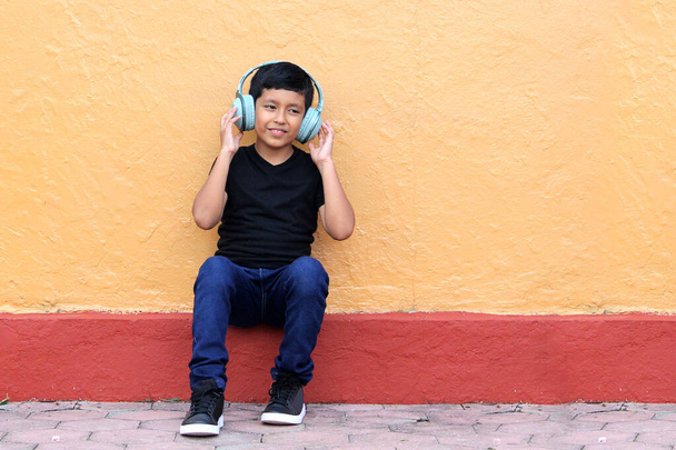 Ragazzo latino-americano di 9 anni con cuffie antirumore per bambini con sindrome dell'aspersore, disturbo dello spettro autistico, ADHD e bambini con sensibilità ai rumori forti - Foto, immagini