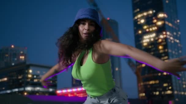 Radostně cool ženské choreografie umělkyně v centru v osvětleném nočním městě na pozadí. Módní funky smíšené závod dívka tanečnice ve sportovním oblečení provedení venkovní ulice tanec pohyby zpomalení - Záběry, video