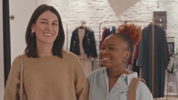 高級デザイナーブティックに立っているカメラで笑っている2人の多様な女性の親友のスローモ肖像画をチェストアップ - 映像、動画