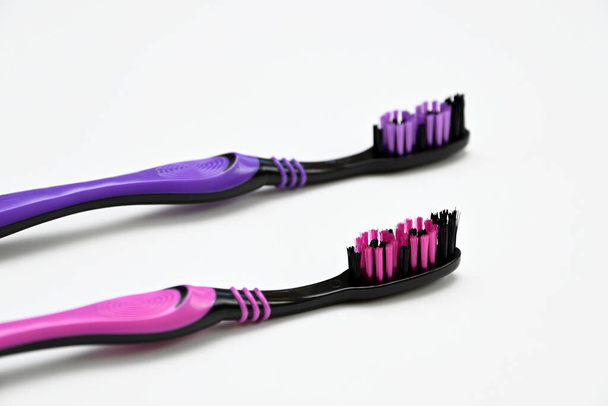 cepillo de dientes rosa y púrpura sobre fondo blanco de cerca - Foto, Imagen