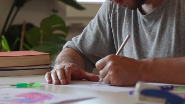 Hombre pintando sentado a la mesa - Metraje, vídeo