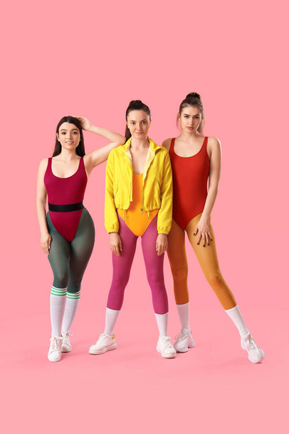 Porträt sportlicher junger Frauen auf rosa Hintergrund - Foto, Bild