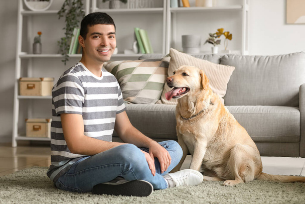 ラブラドール犬と若い男が家に座っている - 写真・画像