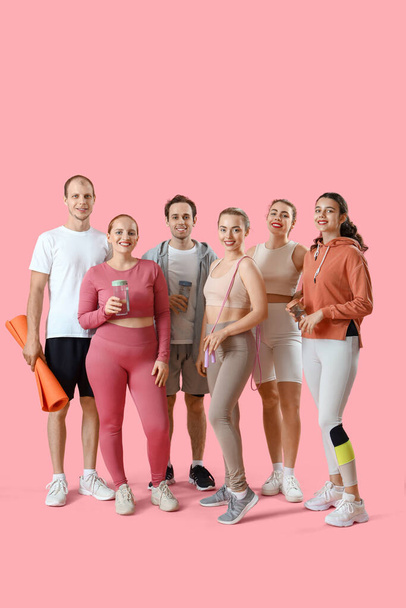 Group of sporty young people with equipment on pink background - Photo, Image