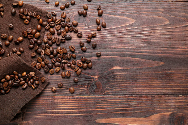 Scattered coffee beans on wooden background - Photo, Image