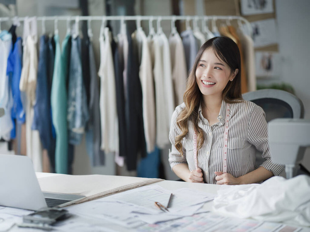Χαμογελαστός Ασιατικός Σχεδιαστής Μόδας Δημιουργώντας Μοντέρνα Ένδυση στο Boutique Shop της. - Φωτογραφία, εικόνα