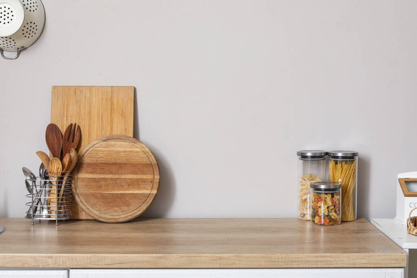 Dřevěná kuchyňská linka s řezacími deskami, nádobkami a sklenicemi - Fotografie, Obrázek