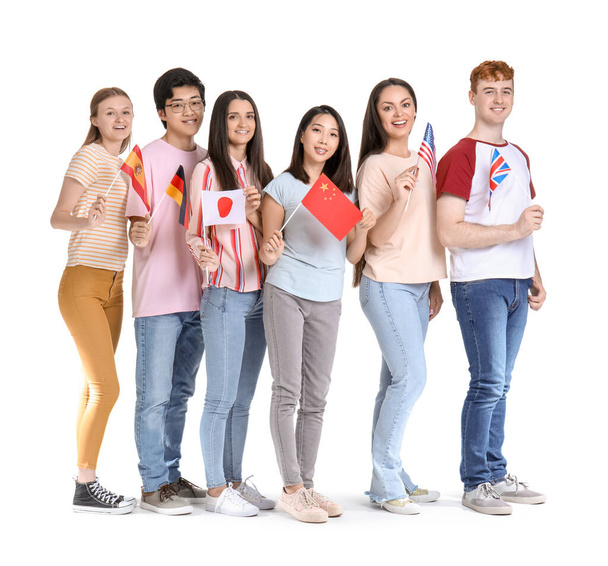 Jonge leerlingen van talenschool met vlaggen op witte achtergrond - Foto, afbeelding