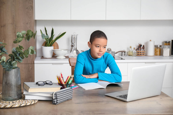 Little African-American boy studying online with laptop in kitchen - Photo, Image