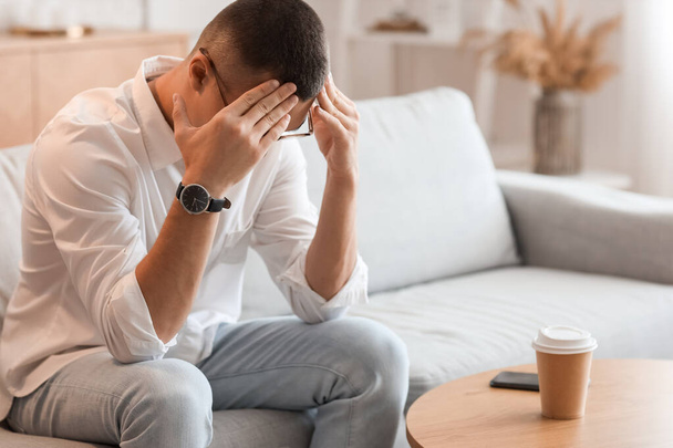 Stressed young man with wristwatch at home - Photo, Image