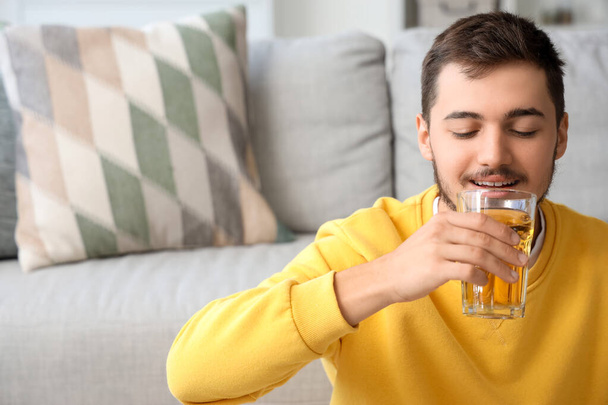 Young man drinking juice at home, closeup - Photo, Image