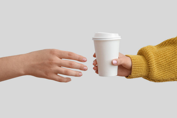 Женские руки с бумажной чашкой на белом фоне - Фото, изображение
