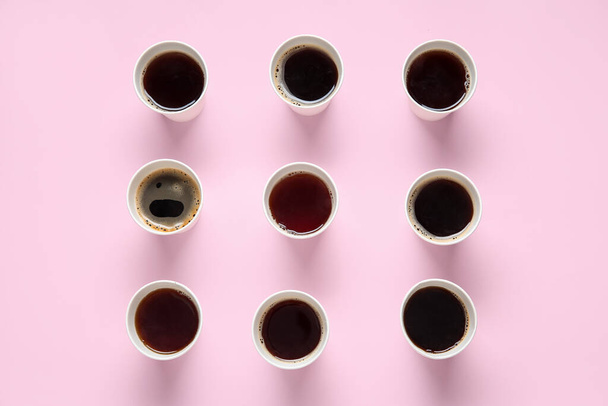 Samenstelling met afhaalpapier kopjes smakelijke koffie op roze achtergrond - Foto, afbeelding