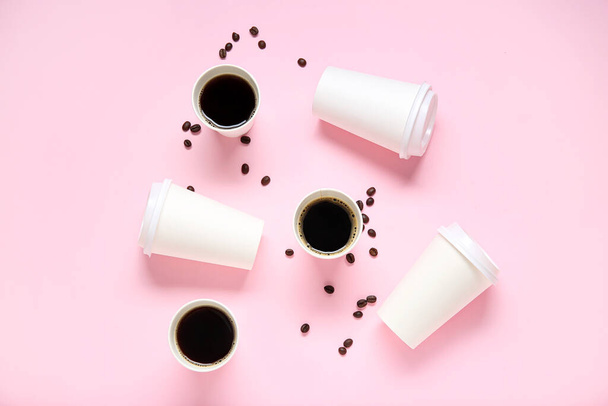 Composição com taças de papel takeaway de café saboroso e grãos no fundo rosa - Foto, Imagem