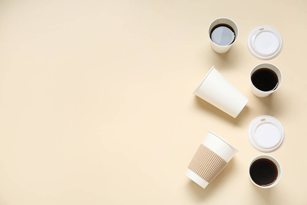 Бумажные чашки на вынос вкусный кофе и крышки на бежевом фоне - Фото, изображение