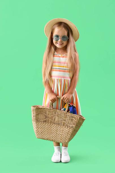 Cute little girl with bag on green background - Photo, Image