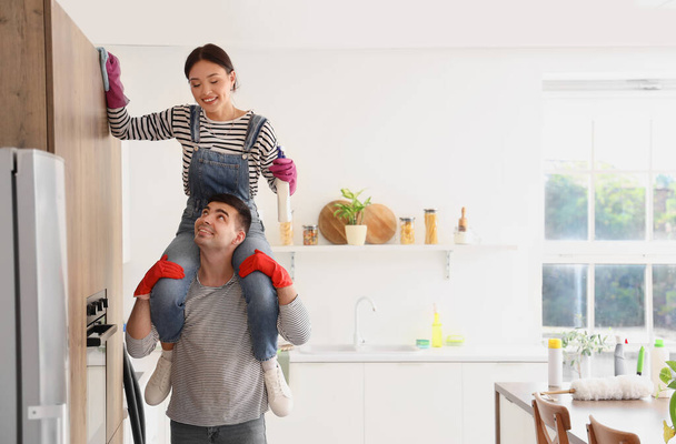 Szczęśliwy młody para sprzątanie w kuchni - Zdjęcie, obraz