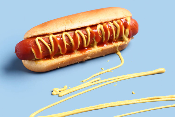 Tasty hot dog with mustard and ketchup on blue background - Photo, Image