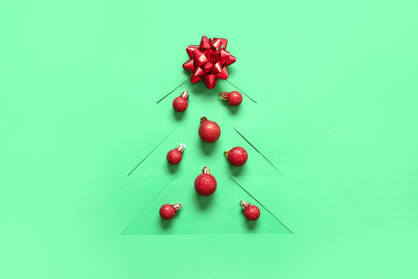 Stříhat zelený papír ve tvaru vánočního stromečku s kuličkami a lukem - Fotografie, Obrázek