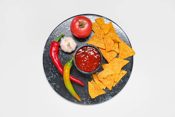 Tábla ízletes salsa mártással, nachos és összetevők szürke alapon - Fotó, kép