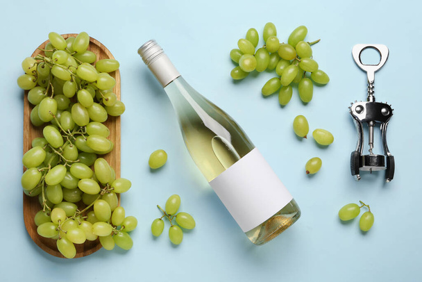Szőlő a fedélzeten és üveg bor üres címkével színes háttér - Fotó, kép