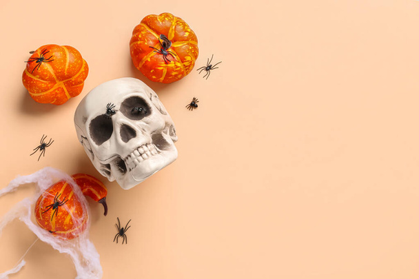 Human skull with pumpkins and spiders on beige background - Photo, Image