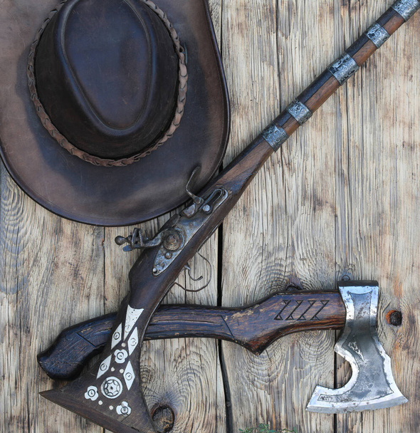 bijl en geweer op oude houten ondergrond - Foto, afbeelding