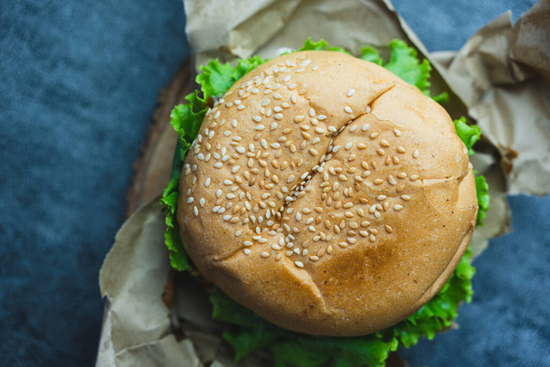 Burger clássico saboroso embalado no papel de embrulho. Vista superior - Foto, Imagem
